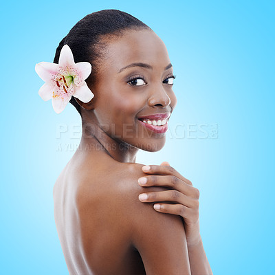 Buy stock photo Portrait, smile and black woman with beauty, flowers and skincare on a blue studio background. Face, African person and model with plant or shine with natural cosmetics and aesthetic with dermatology