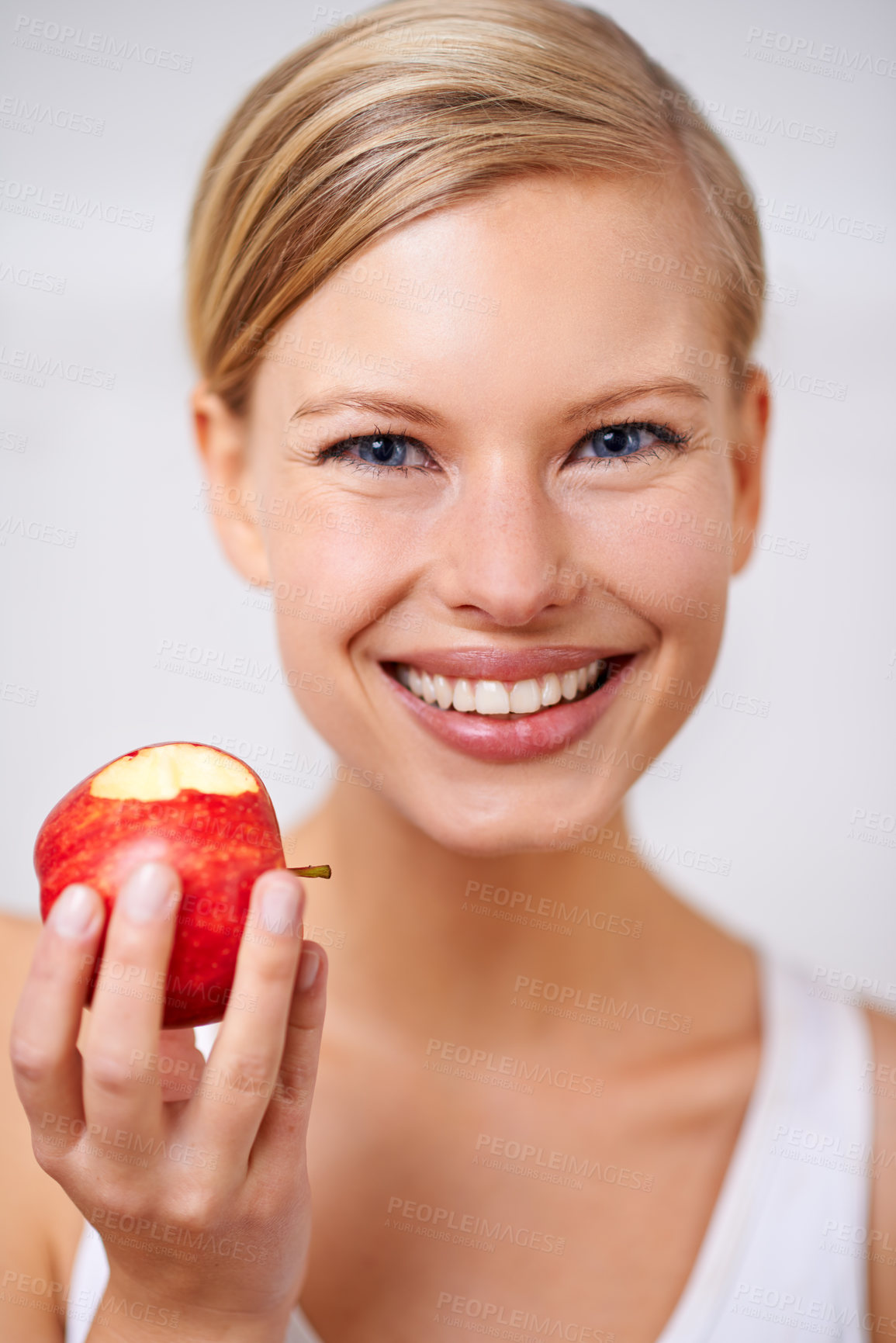 Buy stock photo Happy woman, portrait and nutrition with apple in food, health and wellness on a gray studio background. Face of female person with smile and natural organic red fruit for vitamins, fiber or snack