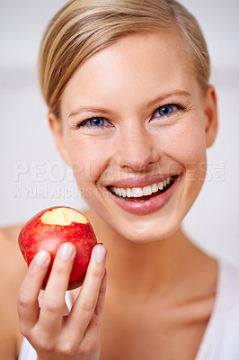 Buy stock photo Happy woman, portrait and nutrition with red apple in fitness, health and wellness on a gray studio background. Face of female person with smile and natural organic fruit for vitamins, fiber or snack