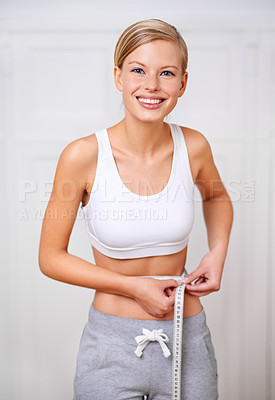 Buy stock photo A portrait of a beautiful young woman measuring her waist