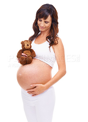 Buy stock photo Smile, pregnant and woman with teddy bear in studio for care, support and planning for future child. Happy, mother and hand on belly with thinking for gratitude, love and vision on white background