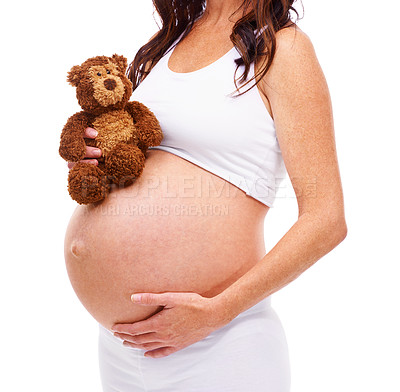 Buy stock photo Woman, pregnant and teddy bear in studio with hand on stomach for care, support or love for future child. Mother, belly and protection of baby with abdomen, wellness and maternity on white background