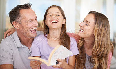 Buy stock photo A cropped shot of a beautiful family sharing a book