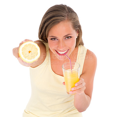Buy stock photo Cropped shot of an attractive young woman drinking orange juice while holding half a lemon