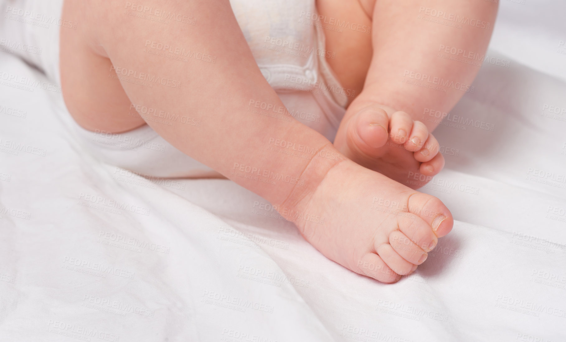 Buy stock photo Cropped shot of a baby boy's legs and feet in a studio