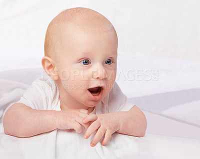 Buy stock photo Cute baby, child and shocked on bed for curiosity, reaction and surprise with laying in nursery at house. Adorable, kid and excited infant in home to relax, observe or wonder for development