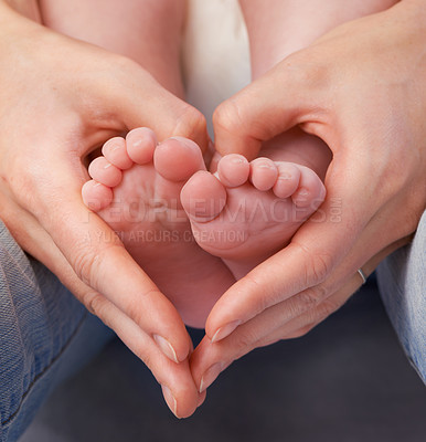 Buy stock photo Cropped shot of a mother's hands making a heart shape around her baby's feet