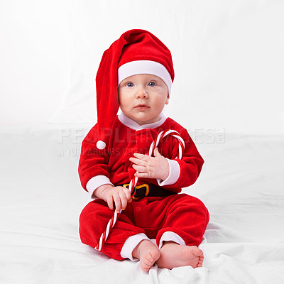 Buy stock photo Baby, portrait and cute with santa outfit for first Christmas holiday, candy cane and white background. Boy toddler, xmas and costume for festive season or celebration, innocent and adorable with hat