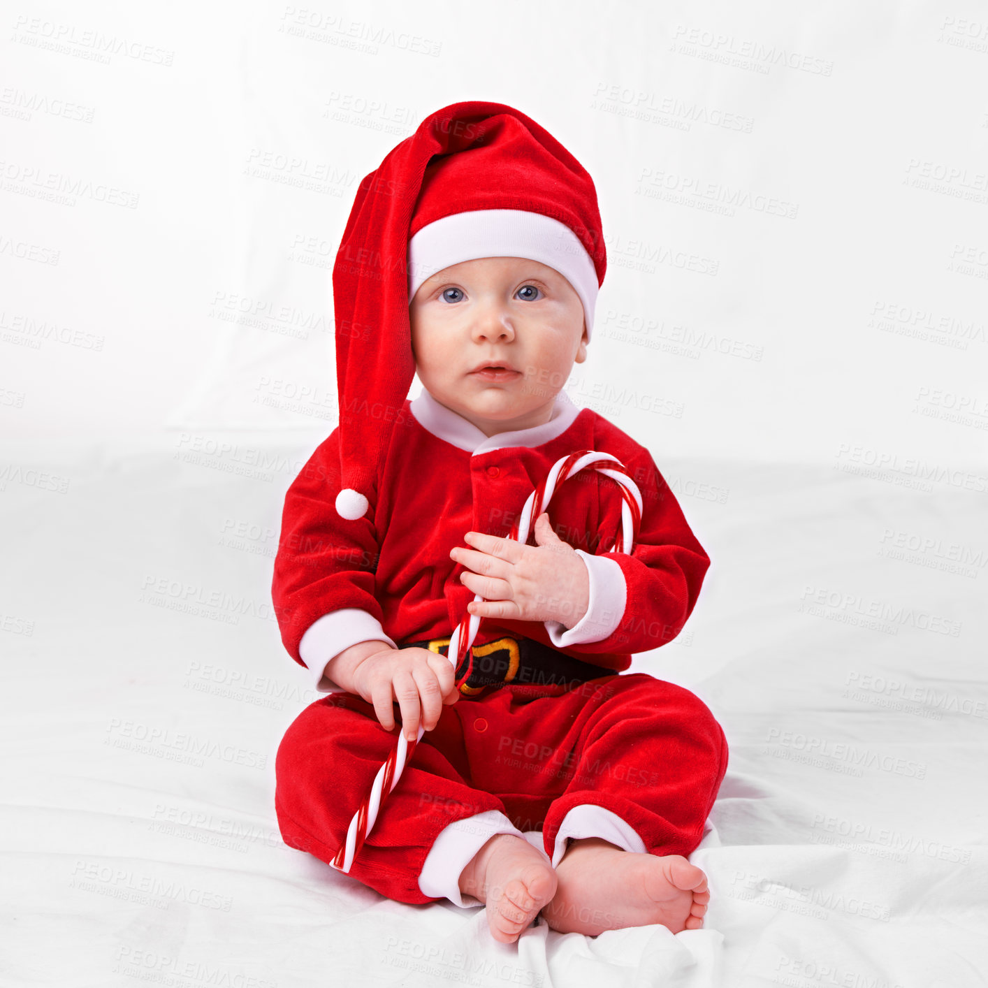 Buy stock photo Baby, portrait and cute with santa outfit for first Christmas holiday, candy cane and white background. Boy toddler, xmas and costume for festive season or celebration, innocent and adorable with hat