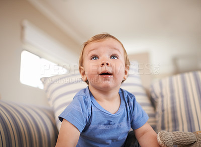 Buy stock photo Toddler, curious or baby on sofa in home for fun playing, happiness or learning in living room. Relax, boy or face of a male kid on couch in lounge for child development or growth in a house alone