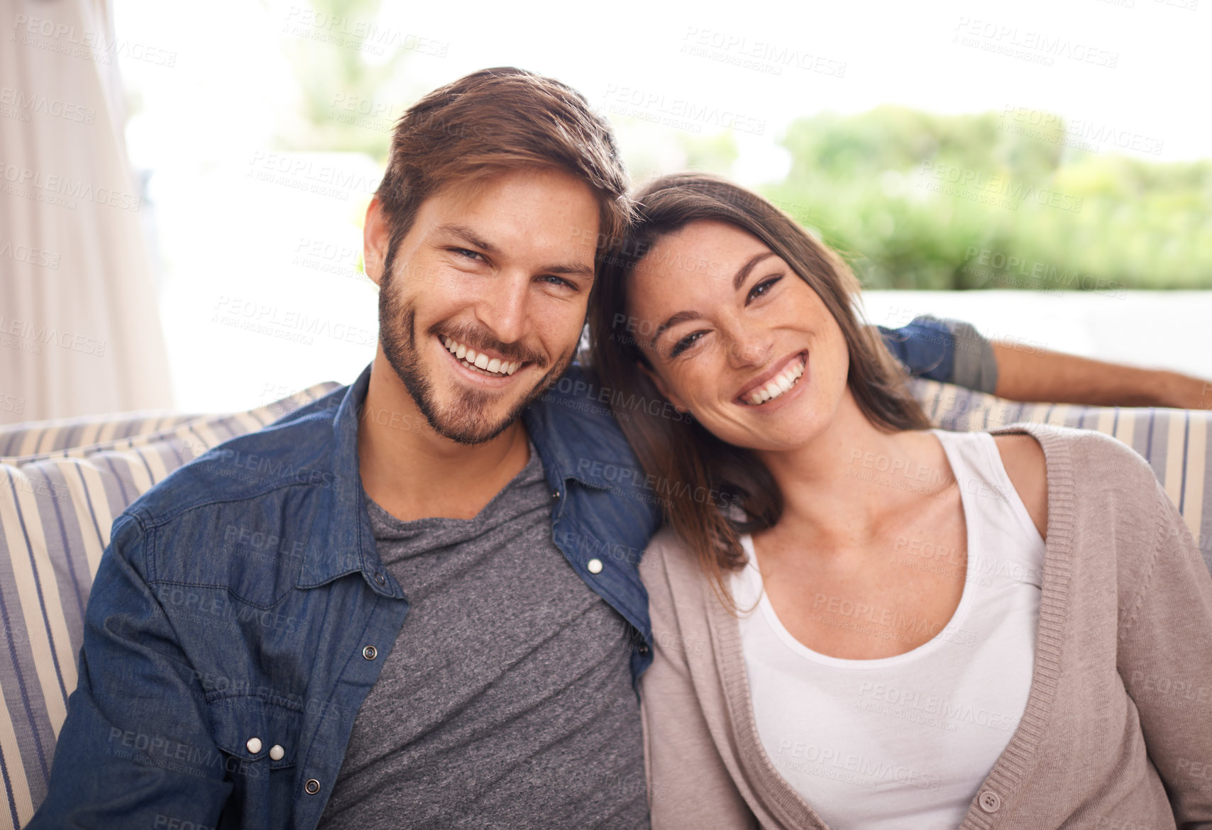 Buy stock photo Portrait of a young married couple relaxing at home