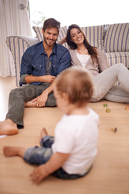 Buy stock photo Family, couple and smile in lounge with toddler for growth, development and bonding on floor. Parents, caregivers and happy with little boy or child in home for activities, games and playing 