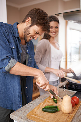 Buy stock photo Happy couple, cooking and cutting of vegetables in house, love and bonding together for lunch on weekend. Man, woman and casserole of healthy food with care and salad in kitchen for romantic dinner