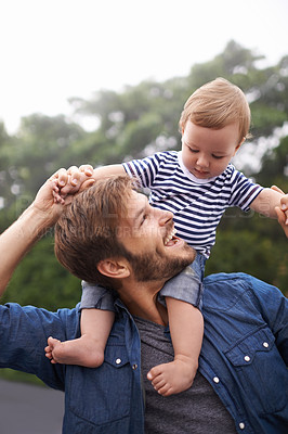 Buy stock photo Shot of young father and his baby boy enjoying a day outside