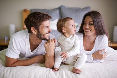 Buy stock photo Happy family, bed and bonding by baby with love, touch and gratitude for healthy growth of child in home. Mother, father or cute son in bedroom for care, relax or parenting with support in apartment