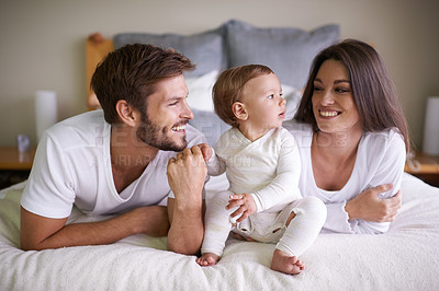 Buy stock photo Happy family, bed and bonding by baby with love, touch and gratitude for healthy growth of child in home. Mother, father or cute kid in bedroom for care, relax or parenting with support in apartment