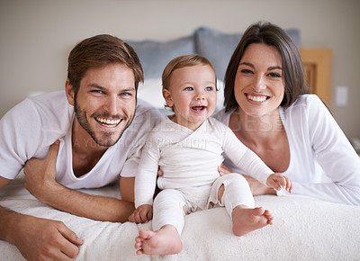Buy stock photo Portrait, smile or parents with baby on bed, love or bonding together for child growth or development. Happy family, dad and mom with pride face for newborn responsibility and parenting care in home