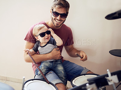 Buy stock photo Cool father, baby sunglasses and drummer musician with music development and child learning. Home, happiness and dad with youth drumming lesson with smile, love and parent care at a family house 
