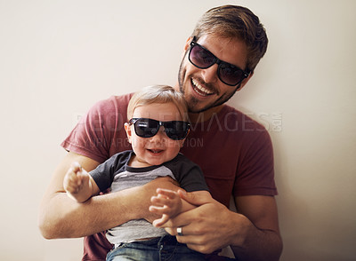 Buy stock photo A young father and his infant son wearing matching sunglasses and laughing