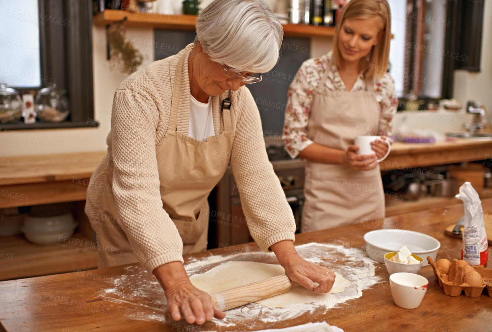 Buy stock photo A grandmother teaching her granddaughter how to bake