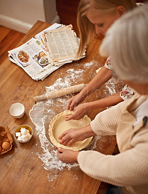 Buy stock photo Above, people and hands baking with dough on table in kitchen and helping process in bakery. Family, prepare and press pastry in dish with flour, meal prep and work with information guide from book