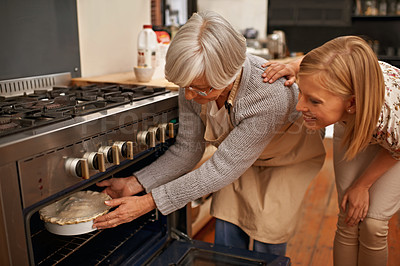 Buy stock photo Shot of a beautiful young woman learning baking tips from her grandmother