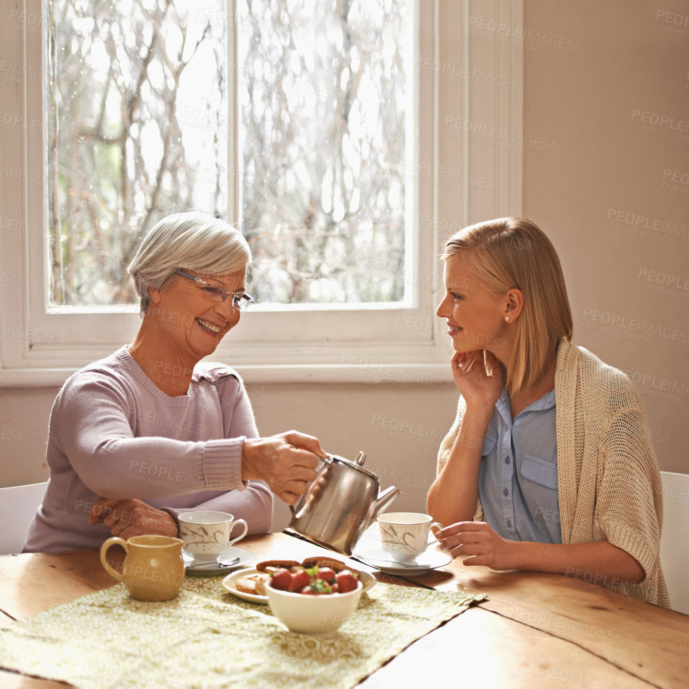 Buy stock photo Family, mother and daughter with tea for drink, relaxing and communication with conversation. Happy people, women and smile with coffee at home in table or kitchen, talking and laughing in house