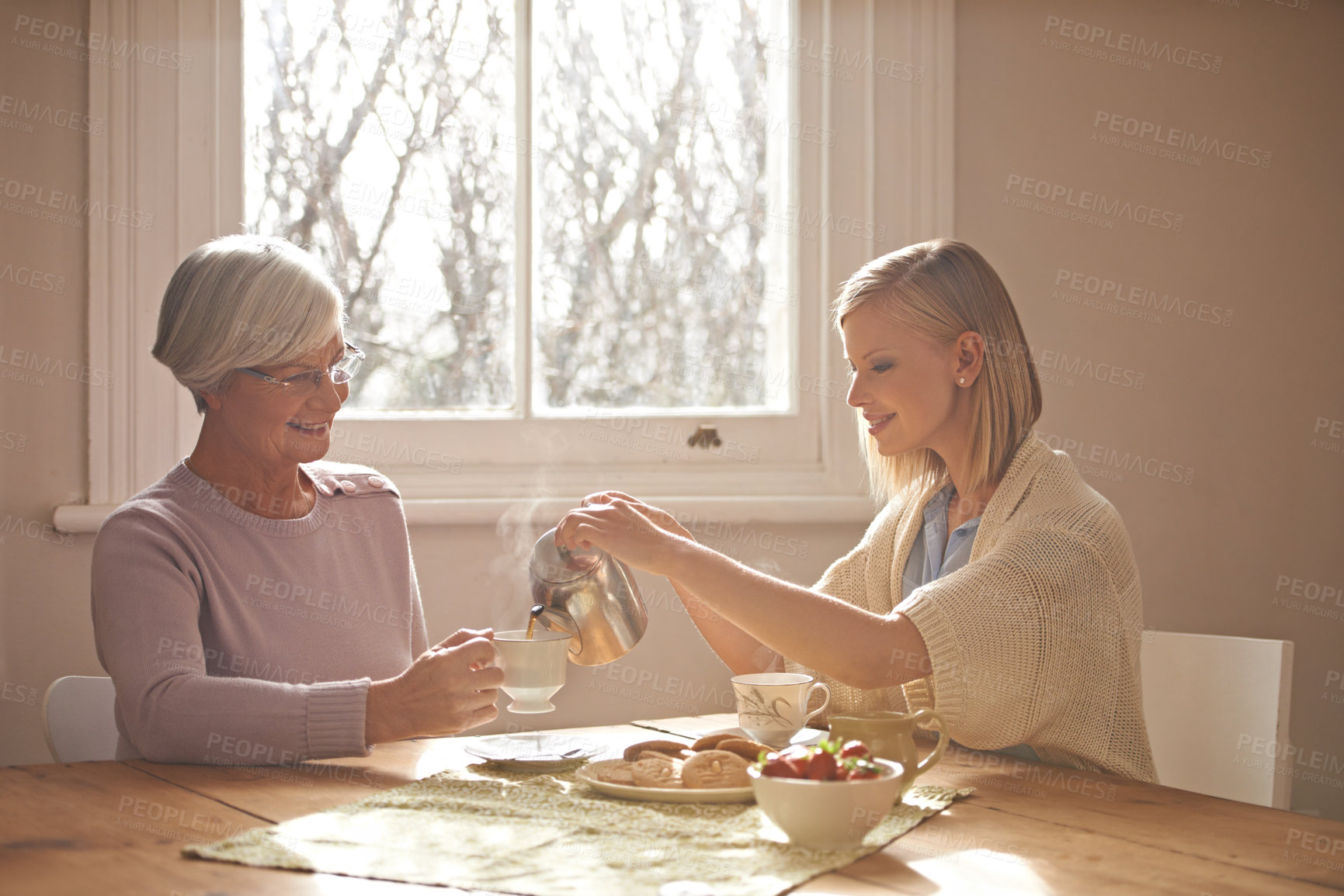 Buy stock photo Happy, grandmother and woman with tea in home for brunch, bonding or visit in retirement. Senior, grandma and girl on coffee break with food, conversation and pouring liquid with steam in morning