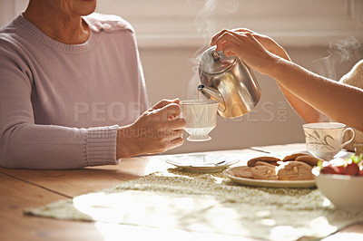 Buy stock photo Cropped view of hands pouring tea from a teapot for a companion