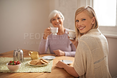 Buy stock photo Portrait, happy woman and senior mother drinking coffee at breakfast, bonding and smile in house. Face, elderly mom and adult with tea cup at table, food and family eating cookies at home together