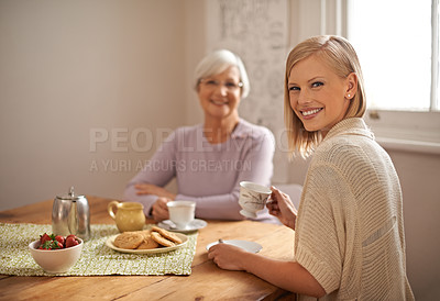 Buy stock photo Portrait, happy woman and elderly mother drinking tea at breakfast, bonding and smile in house. Face, senior mom and daughter with coffee cup at table, food and family eating cookies at home together