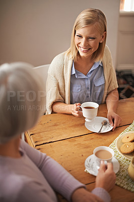 Buy stock photo Daughter, happy woman and senior mother drinking tea at breakfast, bonding and smile. Elderly mom, adult and coffee cup at table for conversation, food and family eating cookies at home together