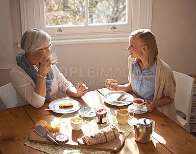 Buy stock photo Happy woman, senior mother and eating breakfast, drinking coffee and conversation at home together. Smile, elderly mom and daughter with tea cup at table, food and family with healthy cheese on bread