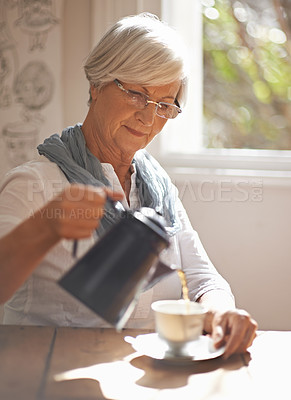 Buy stock photo Senior, woman and tea in home for morning, brunch or calm routine in retirement, holiday or vacation. Mature, person and pouring liquid on coffee break or relax in apartment with drink at window
