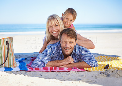 Buy stock photo Parents, girl and portrait on blanket at beach with care, love and bonding in summer to relax on holiday. Father, mother and daughter with picnic, connection and happy by sea in sunshine on vacation
