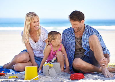 Buy stock photo Mom, dad and girl with sandcastle by ocean on vacation with care, learning or building on holiday in summer. Father, mother and daughter with plastic bucket at beach for game, blanket or happy by sea