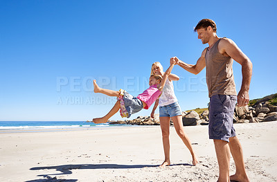 Buy stock photo Holding hands, happy family and swing at a beach with love, support and care while bonding in nature. Freedom, travel and kid with parents at the ocean for morning games, fun or adventure at the sea