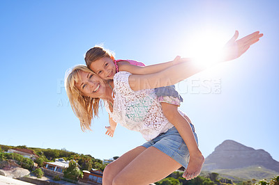 Buy stock photo Happy mother, portrait and beach with child piggyback for fun summer, holiday or outdoor weekend in nature. Mom, little girl or flying with daughter for freedom in sun by ocean coast with blue sky