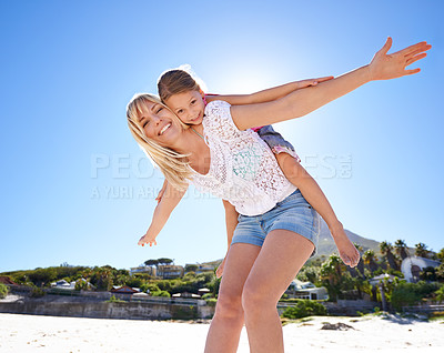 Buy stock photo Happy mom, portrait and beach with child piggyback for fun summer, holiday or outdoor weekend in nature. Mother, little girl or flying with daughter for freedom in sun by ocean coast with blue sky
