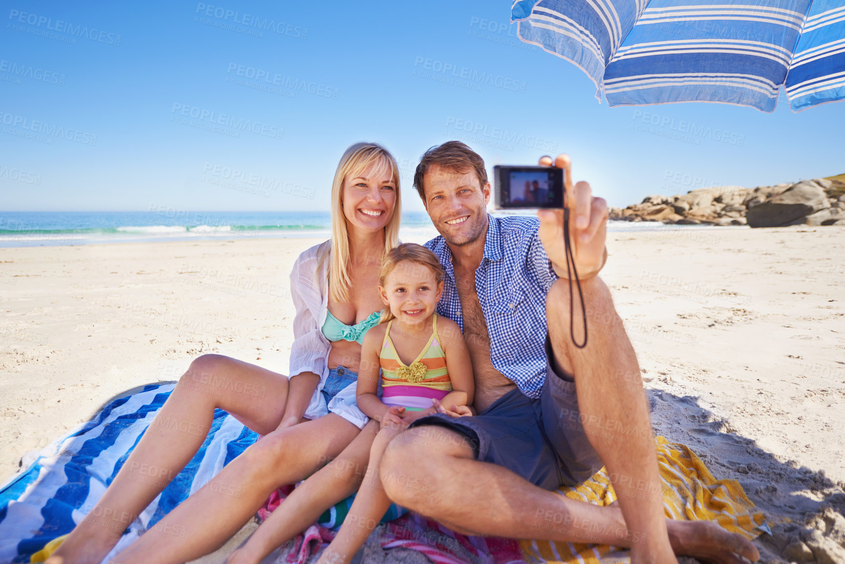 Buy stock photo Happy family, beach and relax with selfie for photography, picture or moment in outdoor nature. Mother, father and child with smile for photo, capture or bonding memory together on the ocean coast