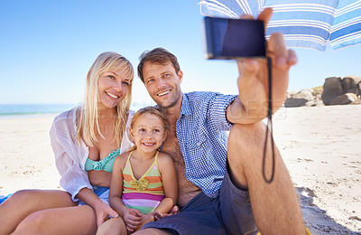 Buy stock photo Happy family, beach and relax with selfie for picture, moment or photography in outdoor nature. Mother, father and child with smile for photo, camera or bonding memory together on the ocean coast