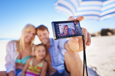 Buy stock photo Happy family, beach and selfie with camera for photography, picture or moment in outdoor nature. Mother, father and child with smile for photo, capture or bonding memory together on the ocean coast