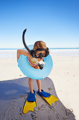 Buy stock photo A cute little girl standing on the beach with all her swimming gear