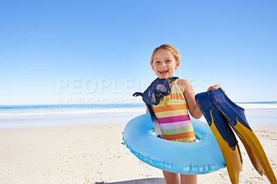 Buy stock photo Beach, child and vacation for swimming in summer with portrait in tranquil environment. Girl, smile and excited person on sand with costume, inflatable and goggles in sun for safety and caution 