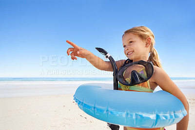 Buy stock photo Girl, smile and goggles for swimming at beach, pointing and equipment for water on holiday. Female person, child and happy on tropical vacation in outdoors, inflatable and blue sky for mockup space