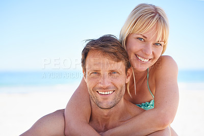 Buy stock photo A happy couple sitting on the beach smiling at the camera