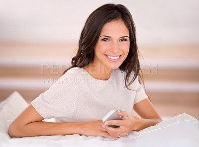 Buy stock photo Portrait, smartphone and woman on home sofa in living room for relax, text and social media. Face, smile and female person on couch for leisure, rest and comfortable weekend in lounge of apartment.