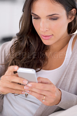 Buy stock photo Woman, phone and texting on sofa in home for communication, web chat or reading blog in living room. Girl, person and smartphone with mobile application, typing or scroll on couch for social media