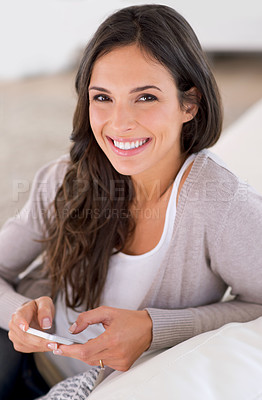 Buy stock photo Woman, phone and texting on couch in portrait for contact, web chat and notification in living room. Girl, person and smartphone with smile for mobile app, pride and scroll in home on social network