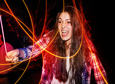 Buy stock photo Sparklers, night and outdoor with teenage girl, excited and shouting with happiness or cheerful. Person, fireworks and tradition with New Years party or event with celebration or evening with culture